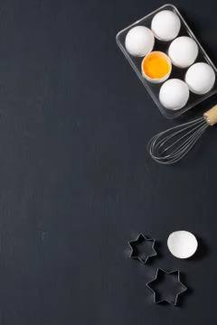 Baking background with eggs, whisk and star cookie cutters Stock Photos