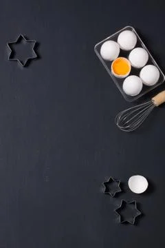 Baking background with eggs, whisk and star cookie cutters Stock Photos