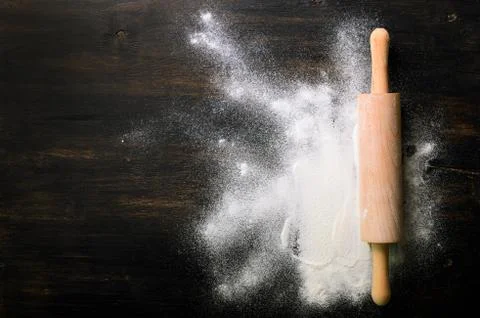 Baking background with free space for your text. Rolling pin and flour on black Stock Photos