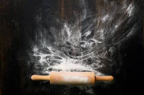 Baking background with free space for your text. Rolling pin and flour on black Stock Photos