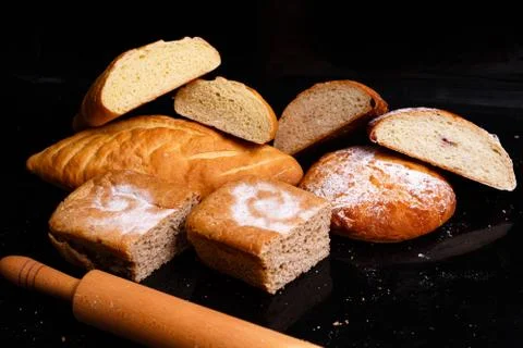 Baking on a black background with a rolling pin. Lots of pastries and bread. Foto stock