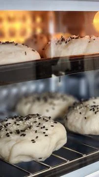 Baking Bread: Close-up of Sesame Seed Buns in Oven. Warm Lighting. Stock Photos