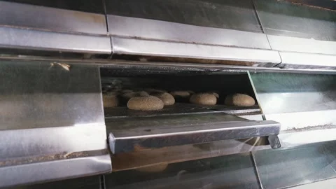 Baking bread in an industrial oven at a bakery. Bread hot in the oven. Stock Footage 263306119