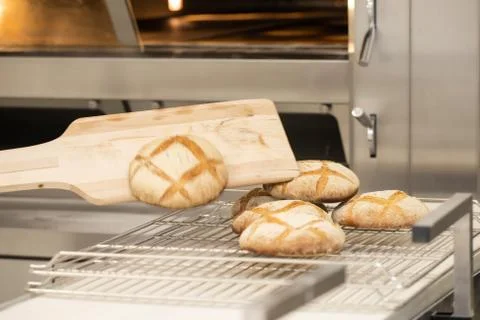 Baking bread in the oven in bakery. Stock Photos