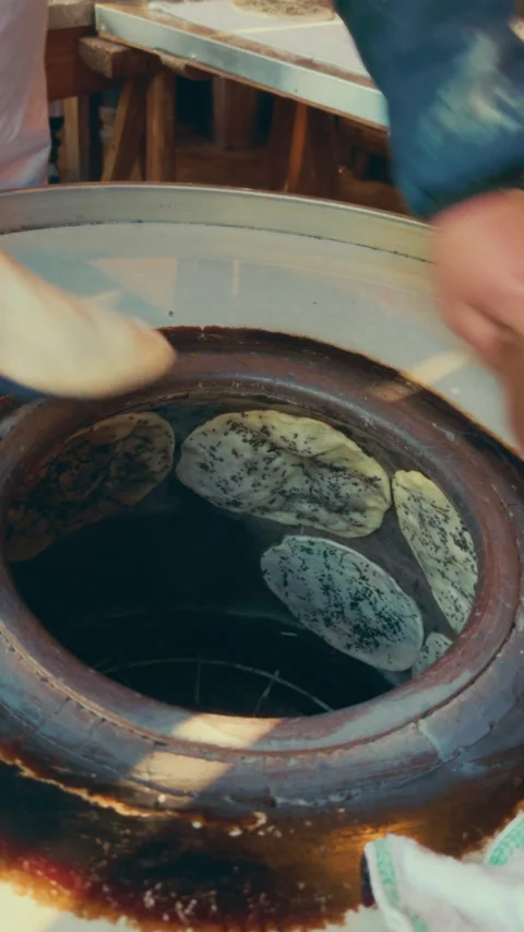 Baking bread in traditional clay oven in Wuzhen, China, focusing on texture and Video stock 305522614