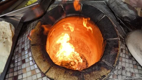 Baking bread in a traditional Indian oven Stock Footage 344843002