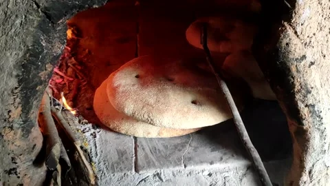 Baking bread in a traditional way in a wood fire oven and flatbread is Stock Footage 204778431