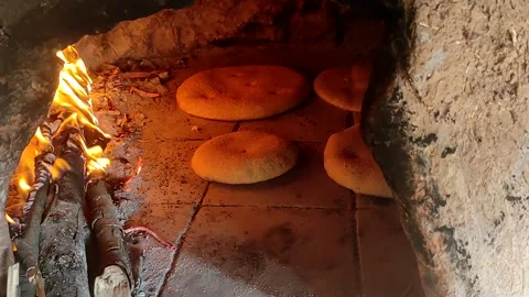 Baking bread in a traditional way in a wood fire oven and flatbread is Stock Footage 204778443