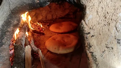 Baking bread in a traditional way in a wood fire oven and flatbread is Stock Footage 204781530