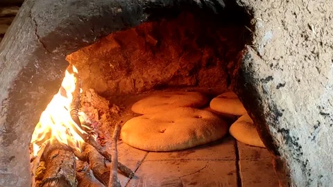 Baking bread in a traditional way in a wood fire oven and flatbread is Stock Footage 204781531