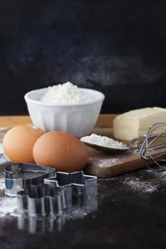 Baking cake ingredients with raw eggs, rolling pin, flour and cookie cutter.. Stock Photos