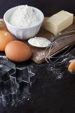 Baking cake ingredients with raw eggs, rolling pin, flour and cookie cutter.. Stock Photos