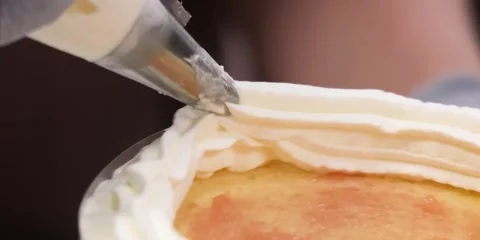 Baking Chef Piping Fresh Whipped Cream Border on Delicious Cake Stock Footage 343589132