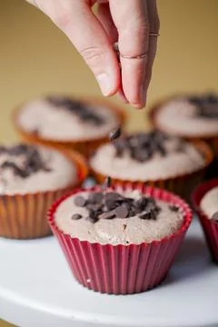 Baking chocolate cupcakes and adding chocolate chips Stock Photos