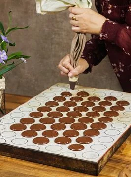 Baking Chocolate Macaron Shells With Piping Bag on Silpat Mat for Homemade Cooki Stock Photos