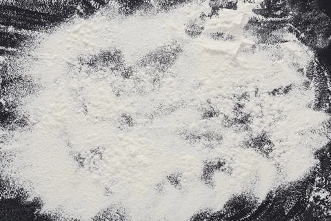 Baking concept on black background, sprinkled flour with copy space Stock Photos