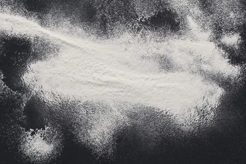 Baking concept on black background, sprinkled flour with copy space Stock Photos
