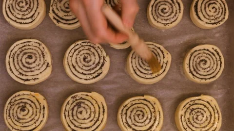 Baking concept. Chef hands dips poppy roll buns with before baking. Video stock 101140070