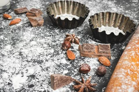 Baking concept, cupcake form and food ingredients on a dark background, prepa Stock Photos