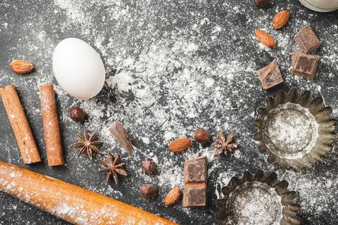 Baking concept, cupcake form and food ingredients on a dark background, prepa Stock Photos