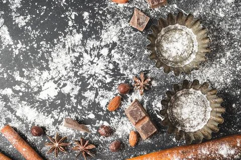 Baking concept, cupcake form and food ingredients on a dark background, prepa Stock Photos