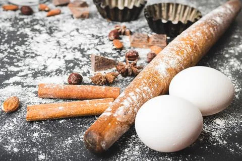 Baking concept, rolling pin, eggs, cupcake form and food ingredients on a dar Stock Photos