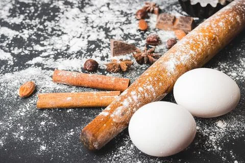 Baking concept, rolling pin, eggs, cupcake form and food ingredients on a dar Stock Photos