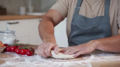Baking concept. Unrecognizable male hands knead dough against the background of Stock Footage 211631898