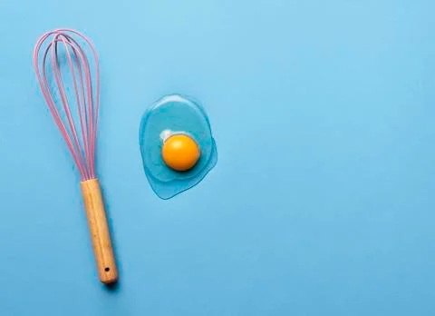 Baking concept with a whisk and egg yolk Stock Photos