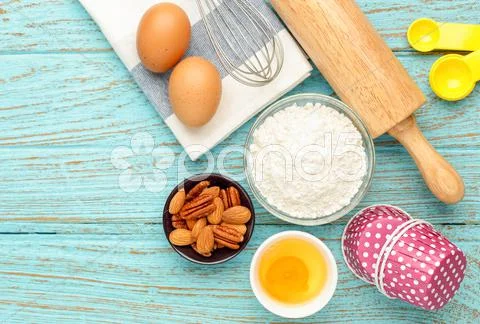 Baking cupcake with ingredients flour eggs almond and utensils from above for Stock Photos