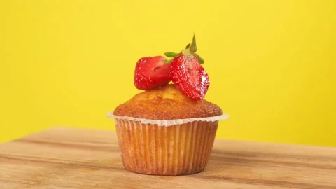 Baking a cupcake with strawberries rotates on a yellow background. Stock-Footage 202632813