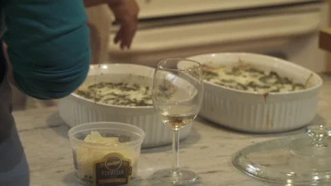 BAKING DISH WITH FRESH CHEESE AND WINE GLASS IN FOREGROUND Stock Footage 102237652