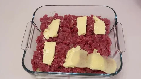 In a baking dish lay the potato slices on the ground meat Stock Footage 165234806