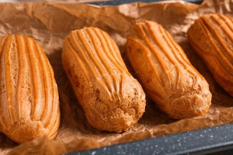Baking dish with tasty eclairs, closeup Stock Photos