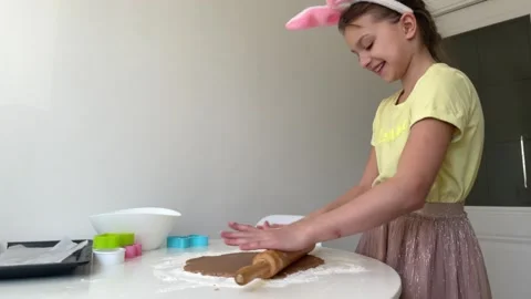 Baking Easter gingerbread cookies. little happy girl bakes cookies for easter Stock Footage 268705208