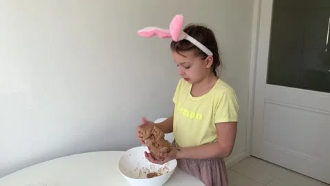 Baking Easter gingerbread cookies. little happy girl bakes cookies for easter Stock Footage 268705266