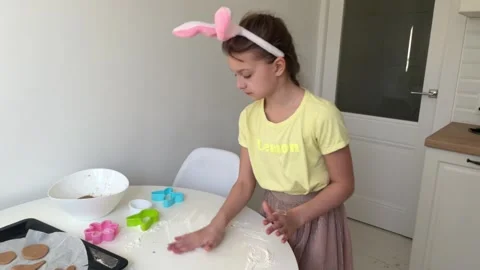 Baking Easter gingerbread cookies. little happy girl bakes cookies for easter Stock Footage 268705309