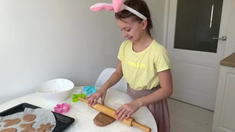Baking Easter gingerbread cookies. little happy girl bakes cookies for easter Stock Footage 268705342