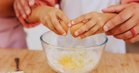 Baking, egg and hands of child with parent in kitchen for learning, help and Stock Photos