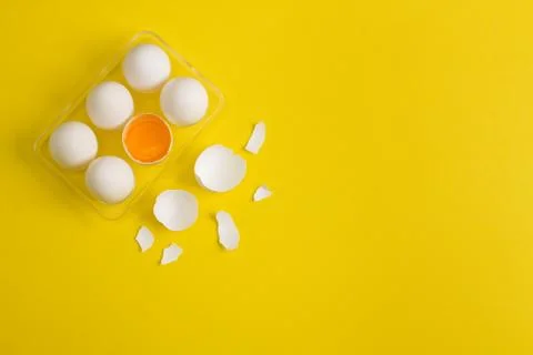 Baking flat lay background with eggs and eggshell on yellow. Stock Photos