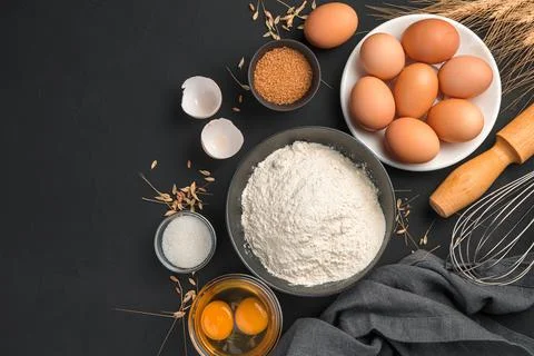 Baking, flour, eggs, sugar, rolling pin on a black background with space to c Stock Photos
