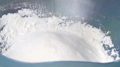 Baking Flour Falling into a Blue Mixing Bowl Stock Footage 253764737