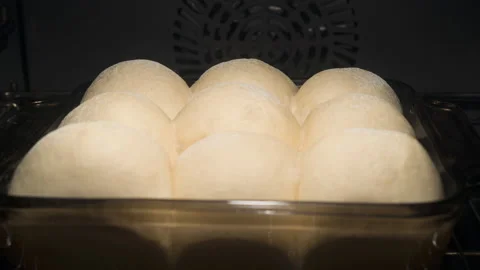 Baking of fluffy dinner bread rolls sprinkled with flour on top Stock Footage 145537315