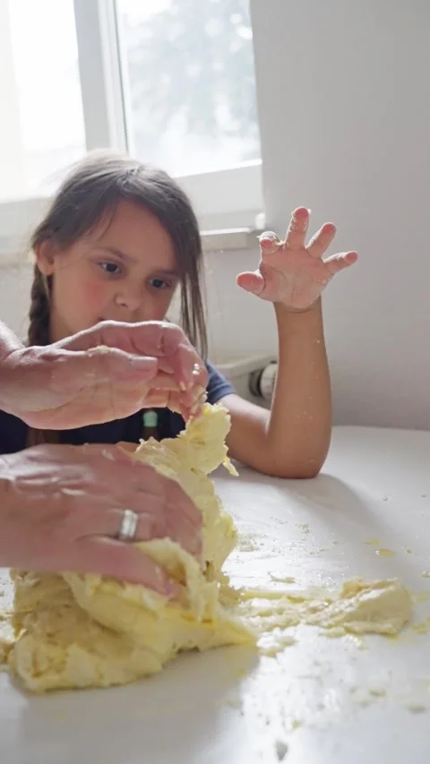 Baking Fun A Child Enthusiastically Engaging in Dough Preparation Alongside an Stock Footage 314619191