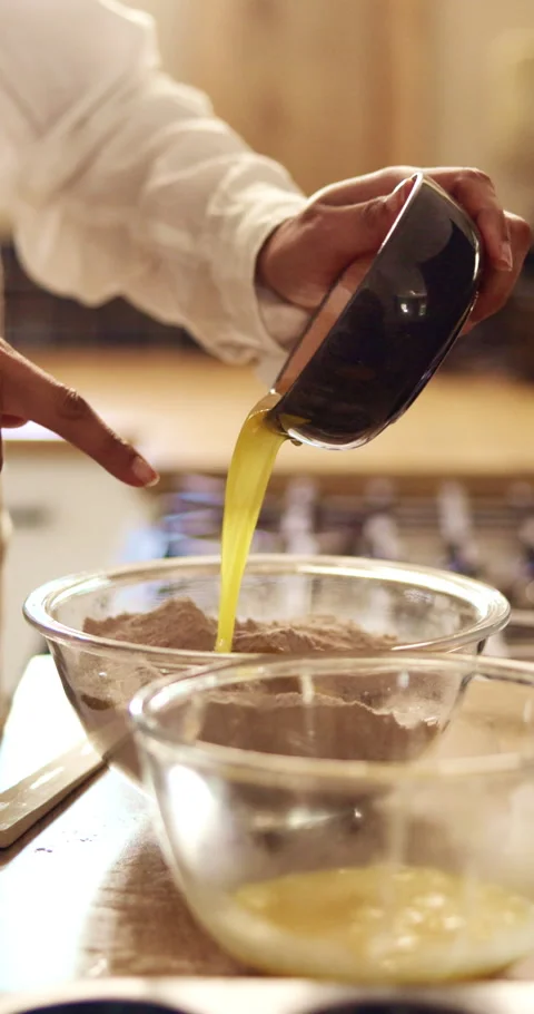Baking, hands and mixing eggs in home for cake batter, pour raw ingredients and Stock Footage 343175365