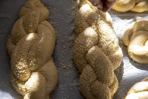 Baking homemade challah bread. A braid with sesame seeds in a pan before baking Stock Photos