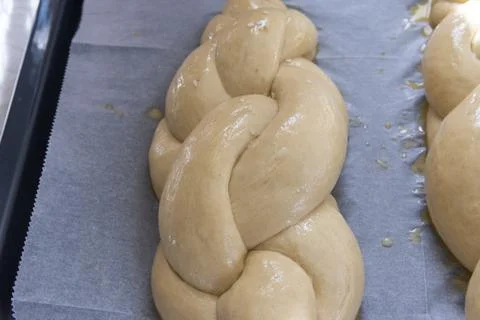 Baking homemade challah bread. A braid with sesame seeds in a pan before baking Stock Photos