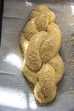 Baking homemade challah bread. A braid with sesame seeds in a pan before baking Stock Photos