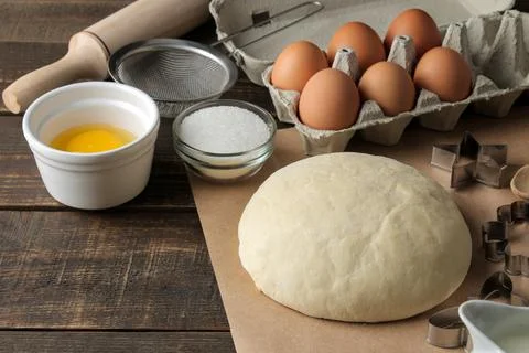 Baking ingredients. baking tools. dough and butter, eggs, sugar, milk on a br Stock Photos