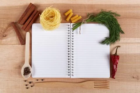 Baking ingredients for cooking and notebook for recipes on a wooden board. Stock Photos